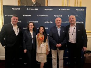 Five people stand in front of a backdrop at AdvisorHub's annual RIA masterclass.